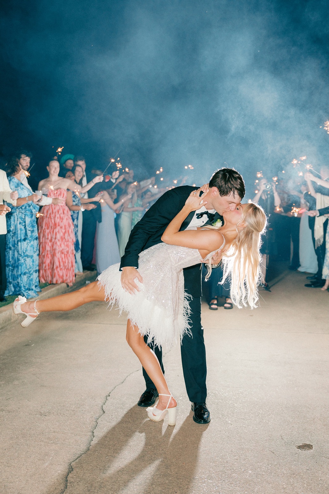 Bride and groom kiss as they exit their Reynolds Lake Oconee wedding reception